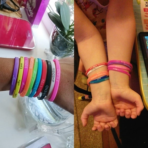 Macro detail of colorful silicone wristbands featuring inspirational printed words like Success