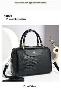 Details einer schwarzen Handtasche mit Krokostruktur, goldenem Logo und Metallbeschlägen