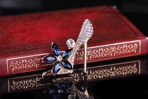 Macro detail of high heel brooch with blue marquise crystals and pavé rhinestones