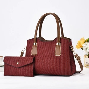 Deep burgundy textured tote bag with matching envelope pouch and brown leather handles