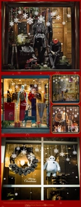 Close-up of white snowflake window clings with Merry Christmas text on glass surfaces