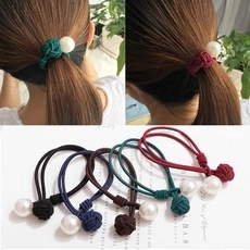 Detailed view of elastic hair ties with pearls and fabric knots in various classic colors