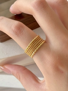 Close-up of minimalist gold S925 sterling silver multi-layered textured rings on hand