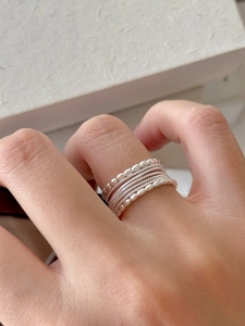 Close-up of stacked S925 sterling silver rings with beaded and smooth textures