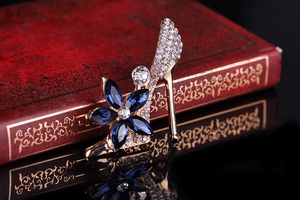 Detailed view of gold high heel brooch with white rhinestones and blue crystals