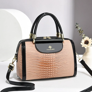 Elegante Handtasche in Nude-Rosa mit Kroko-Prägung, schwarzen Lackgriffen und Goldbeschlag