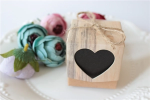 Kraft paper candy box with heart cutout and hemp rope on a decorative white plate
