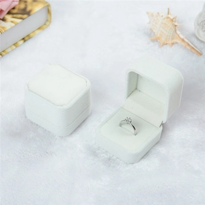Elegant off-white velvet ring jewelry box with a classic diamond solitaire ring