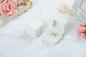 Makro-Detail der weißen Samt-Schmuckschatulle mit elegantem Design und silbernem Diamantring