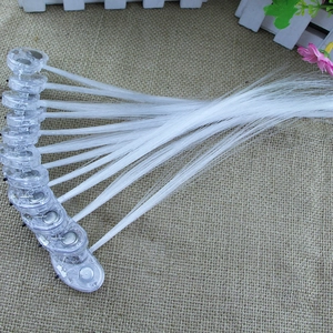 Close-up of LED fiber optic hair braids showing internal button batteries on burlap