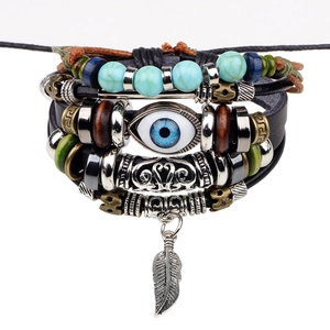 Multilayer leather bracelet with blue evil eye bead and silver feather pendant on white background