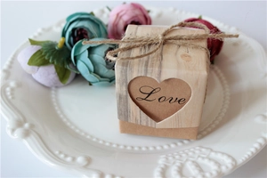 Close-up of kraft paper wedding favor box with heart cutout and rustic jute twine bow