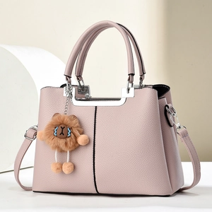 Pink lychee grain leather handbag with a plush lion charm and adjustable shoulder strap
