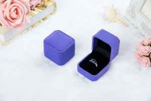 Detailansicht einer lila Samt-Ringbox im offenen und geschlossenen Zustand mit Ring