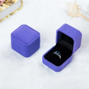 Detail view of purple velvet square ring box with black flocking lining and jewelry