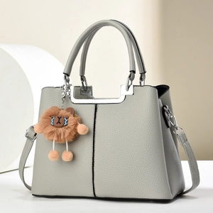 Elegant light gray pebbled leather handbag with silver hardware and lion plush charm