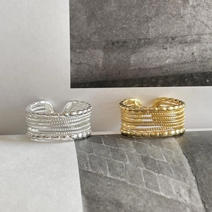 Macro view of textured multi-layer wide band open ring in gold and silver finish