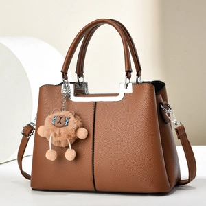 Elegant brown pebbled leather tote with top handles and a cute lion charm accessory
