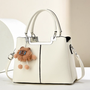 Detail of lychee pattern leather bag with silver U-shaped metal trim and bear charm