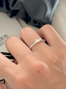 Detail of S925 sterling silver twist ring worn on finger with a stylish lifestyle background