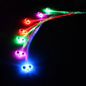 Close-up of colorful LED fiber optic hair clips glowing against a black background