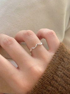 Detailed view of a minimalist S925 sterling silver wavy ring worn on a finger