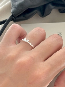 Minimalist 925 sterling silver heart ring worn on finger against a lifestyle background
