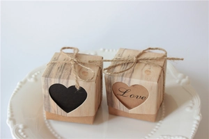 Close-up of kraft paper wedding favor boxes with heart cut-outs and rustic twine bows