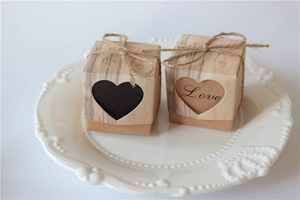 Close-up of kraft gift boxes with hollow heart design and twine bow on a white plate