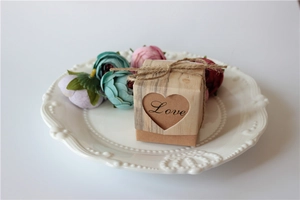 Detail of kraft paper gift box with heart-shaped cutout and rustic twine on ceramic plate