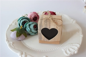 Close-up of vintage kraft paper candy box with heart cutout and jute rope on white tray