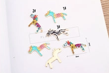 Detail view of colorful horse-shaped alloy pendants with striped and solid patterns