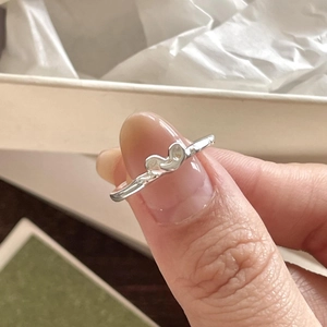 Close-up of a minimalist 925 sterling silver ring featuring a brushed heart-shaped design