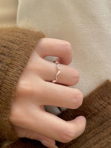 Close-up of minimalist S925 sterling silver wavy ring worn on finger for autumn style