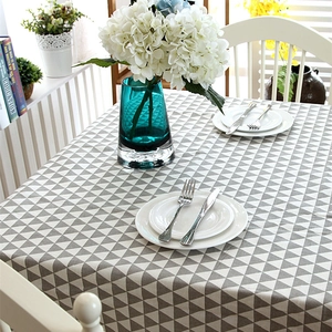 Grey and white geometric triangle tablecloth in a warm home dining setting with flower vase