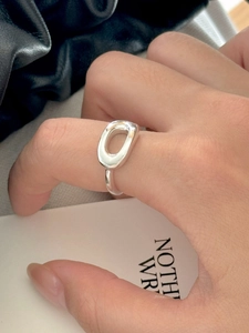 Close-up of minimalist 925 sterling silver hollow oval ring worn on finger with high-polish