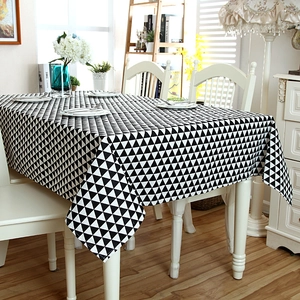 Minimalist black and white geometric triangle lace tablecloth on a wooden dining table