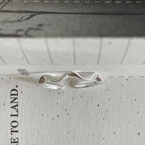 Macro detail of wave-shaped S925 sterling silver ring showing the inner S925 hallmark