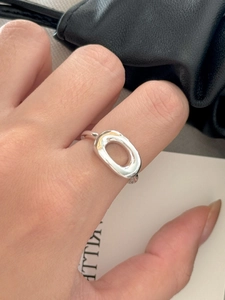 Close-up of minimalist sterling silver open ring featuring hollow oval geometric shapes