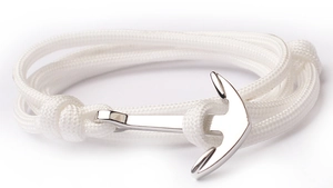 Detail of white nylon braided bracelet featuring a silver anchor-shaped clasp on white background