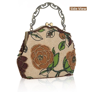 Detail view of vintage beaded floral embroidery and metallic carved handle on linen handbag