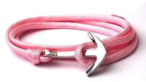 Detailed view of pink braided cord bracelet with a silver anchor-shaped clasp