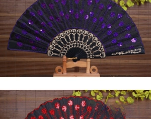 Close-up of vintage black fabric folding fan with purple sequins and gold patterned ribs