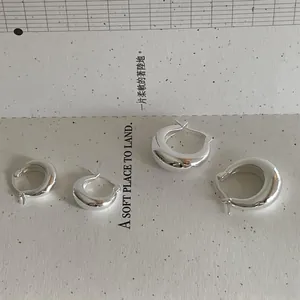 Vue détaillée de créoles polies en argent sterling 925 au style minimaliste chic