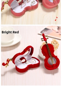 Detail view of red velvet violin jewelry box with gold trim for rings and earrings