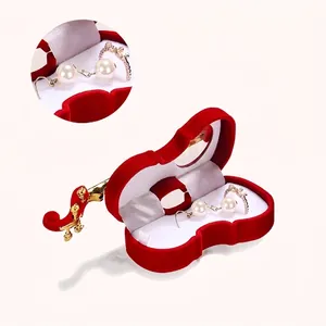 Elegant violin-shaped red velvet jewelry box with white pearl earrings and gold accents