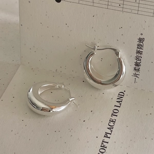 Gros plan de boucles d'oreilles créoles épaisses en argent 925 avec poinçon S925