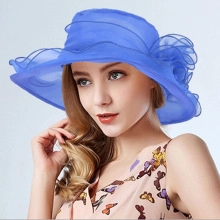 Detail of elegant bright blue organza sun hat featuring a large 3D floral decoration