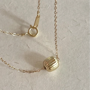 Minimalist S925 sterling silver golden chain with a textured pumpkin bead pendant