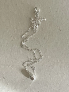 Detail of S925 sterling silver necklace with textured pumpkin pendant on O-chain